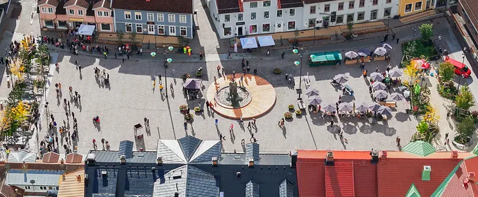 Drönarvy över Stora torget. Marknadsstånd, Malta Johanna och människor som rör sig över torget.